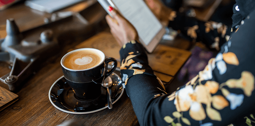 Woman looking at tablet in coffee morning meeting