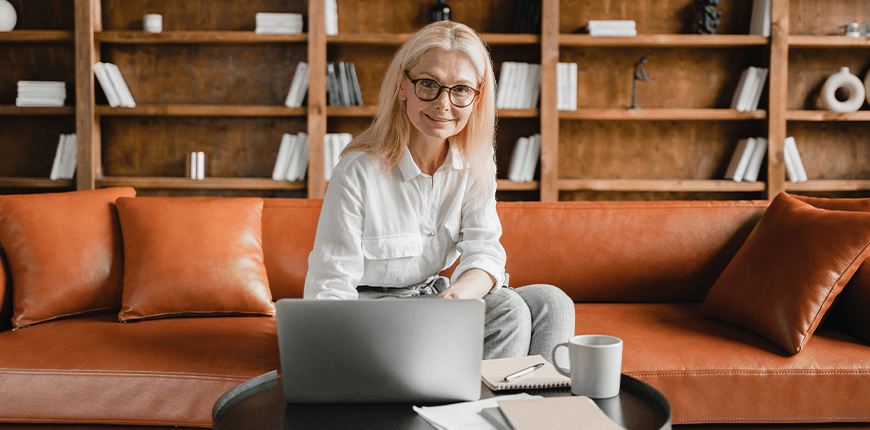 Woman sat on sofa with laptop open